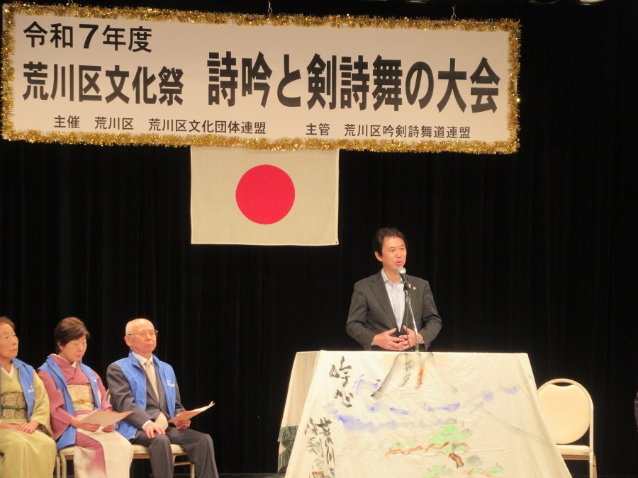 しぎんとけんしぶの大会で挨拶をする区長
