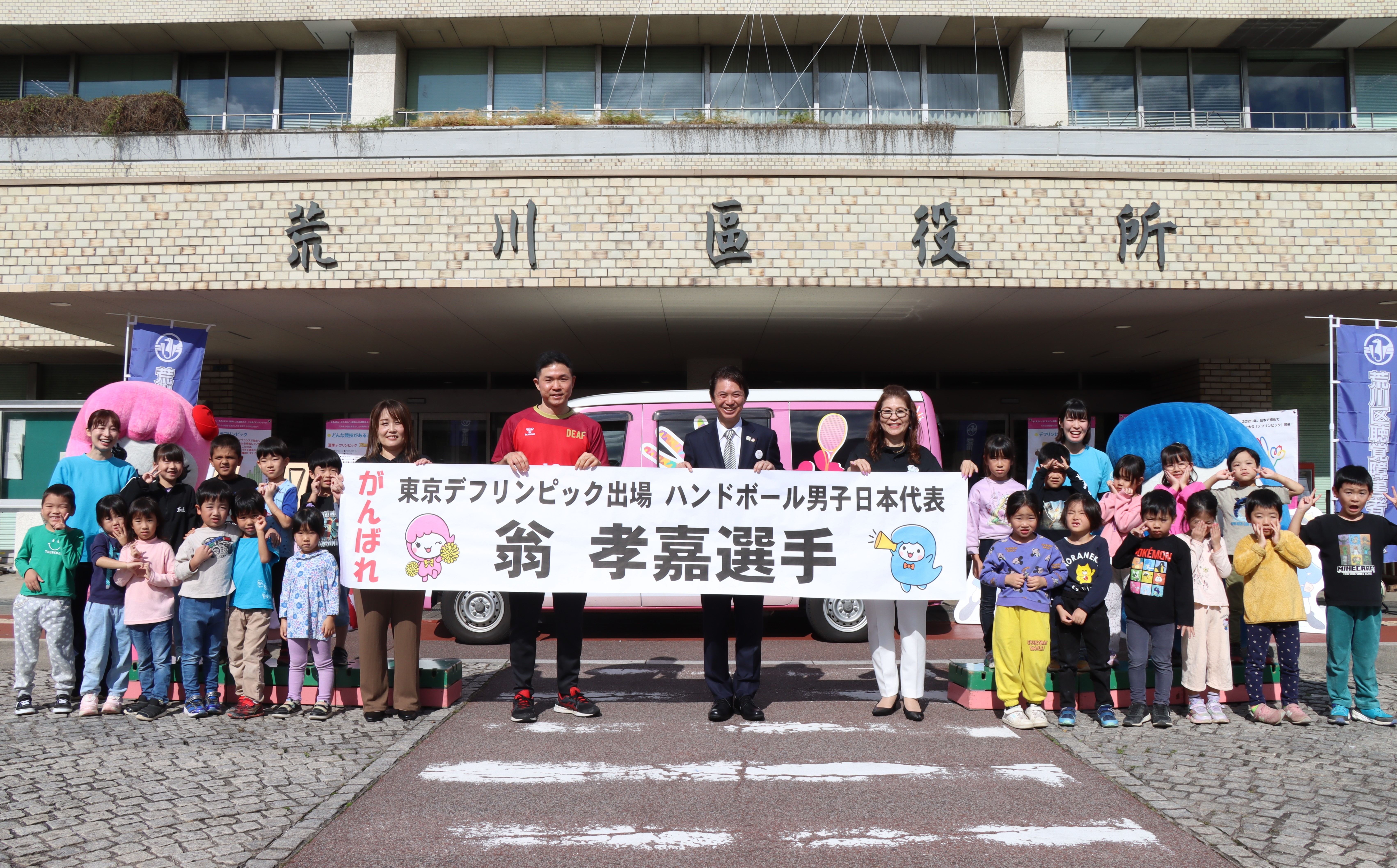 横断幕を持って記念撮影する様子