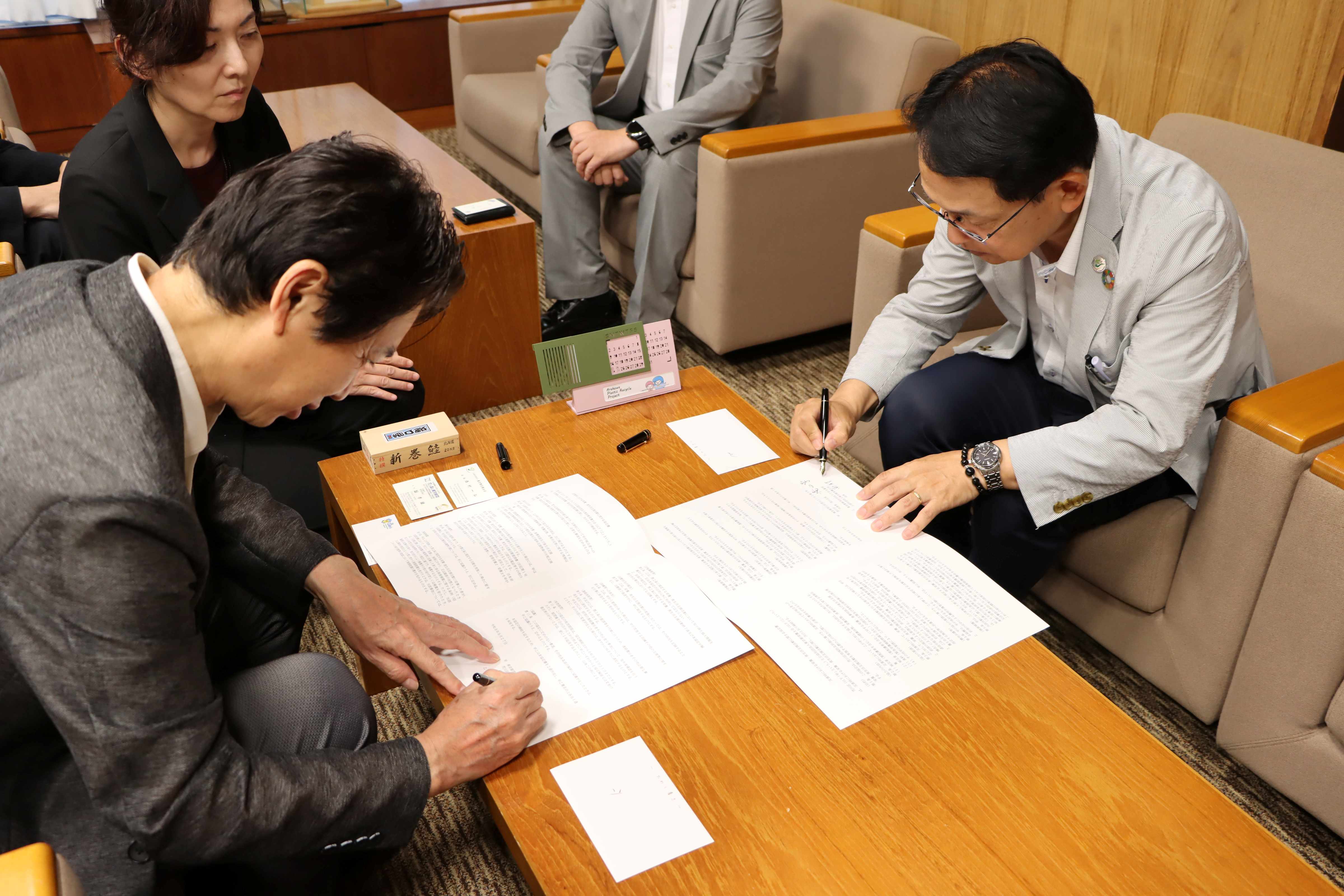 協定書にサインする様子