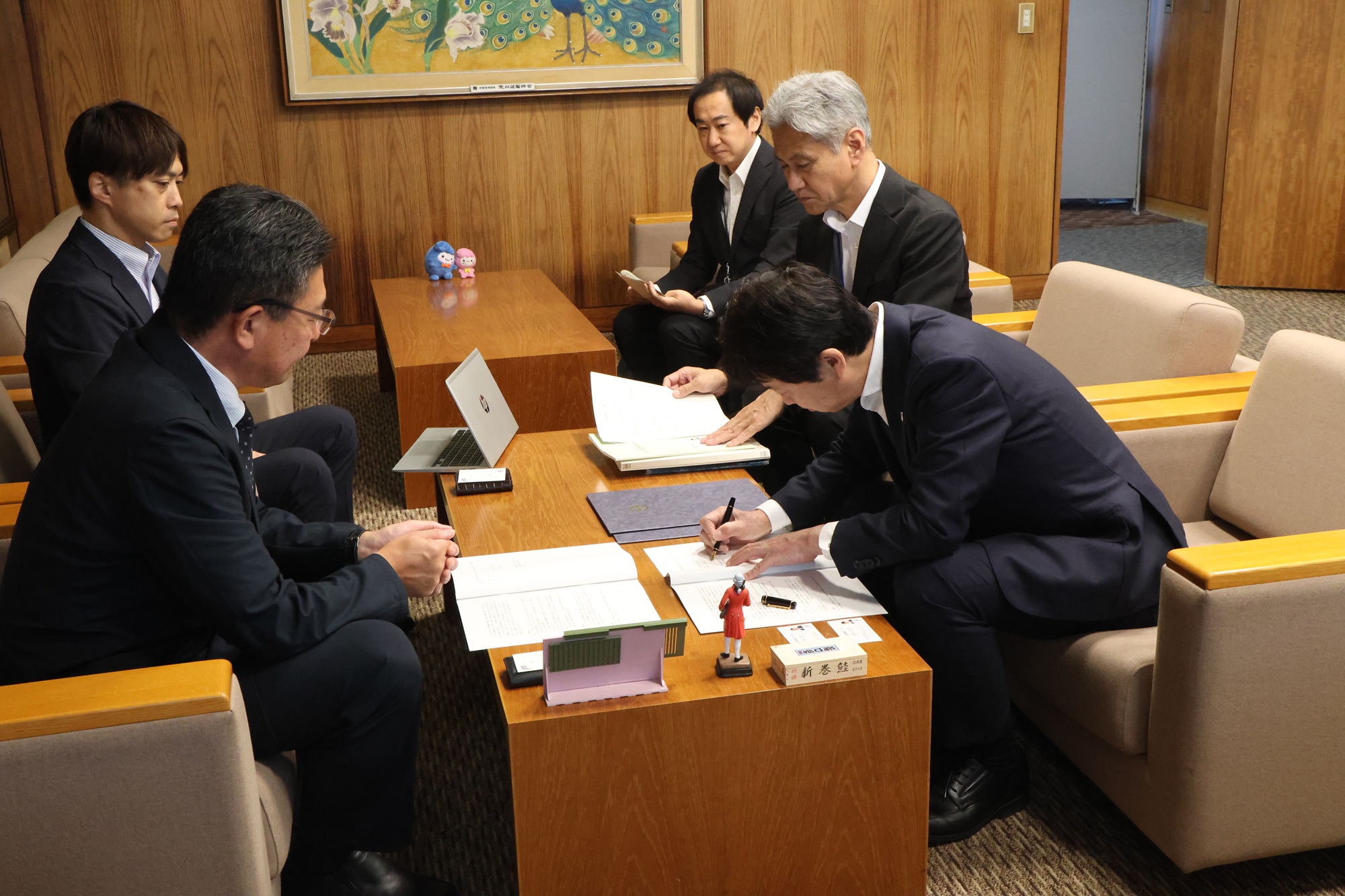 協定書にサインする様子